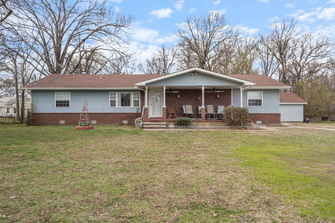 Beautiful 3 bedroom, 2 bath home in lovely growing Siloam Springs. The living area is perfect for relaxation and entertaining. The open kitchen features hardwood cabinets and an eat-in area. A bonus room offers flexible space for an office or additional living area. The primary bedroom includes an en-suite bathroom with a large walk-in shower and closet. A spacious laundry/mud room provides ample space for cleaning up after outdoor activities. Enjoy covered front and rear porches for outdoor relaxation. Outdoor features include raised garden beds, a stocked pond, pasture for livestock, and a barn suitable for hay storage or 4-H projects. A 32x44 shop offers space for hobbies or storage, complete with electric, heating, and a bathroom. Two detached garages provide storage for vehicles, lawn equipment, ATVs, or boats. Perfect for families or outdoor enthusiasts, this home offers a serene country setting with easy access to town amenities. Don't miss this opportunity!