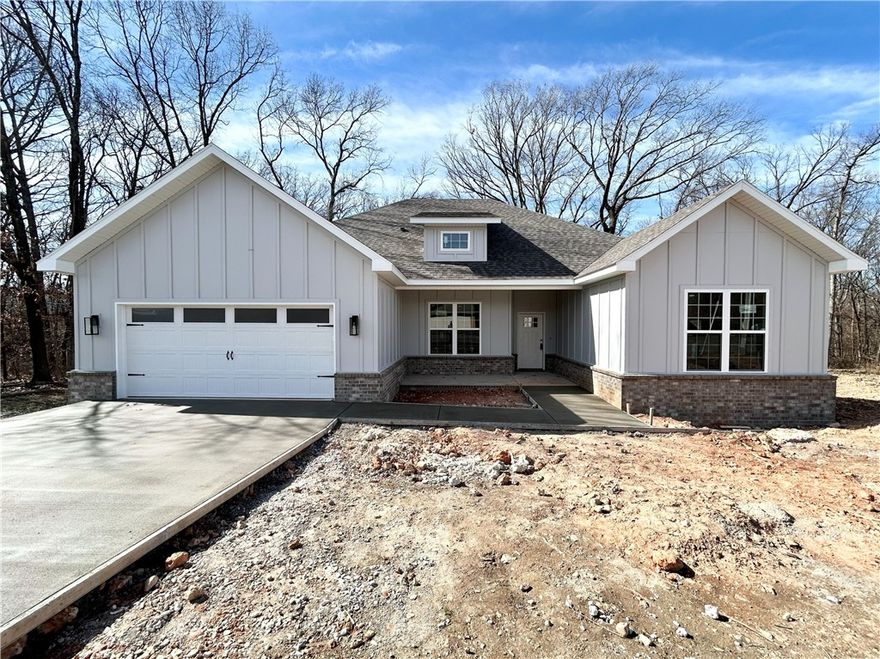 Stunning new construction home on a wooded lot with easy access to I-49! Perfectly situated just minutes from Lake Loch Lomond. Step inside to discover a beautifully designed interior with 3BD's + office, a split floor plan, & custom modern finishes throughout. Wood floors! The spacious living area showcases a beamed vaulted ceiling, creating an inviting atmosphere. The kitchen features sleek 3 cm quartz countertops, a gas range, custom cabinets, and stylish stainless-steel appliances. Retreat to the luxurious primary bath, which boasts a huge walk-in closet, a large custom walk-in tile shower, and a soaking tub. 2 covered patios. As an added bonus, receive $3,500 towards buyer's closing costs when working with the builder’s preferred local lender!