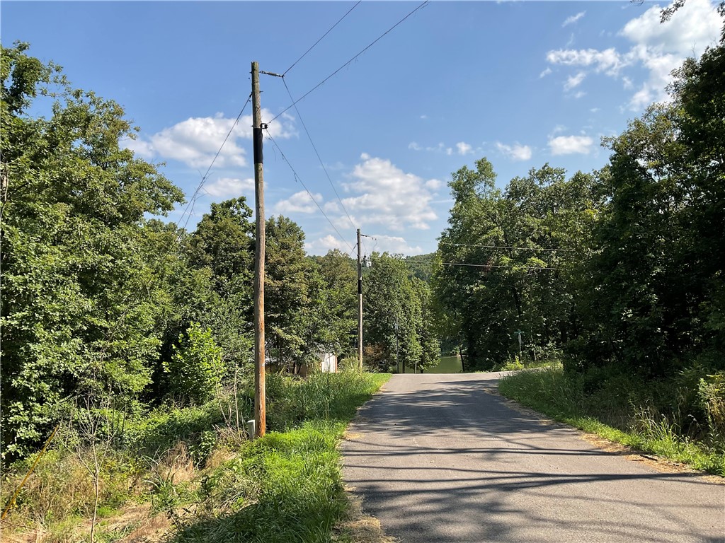 Highly desirable area in Bentonville School District. Near trails and easy assess to Metfield Golf Course. The lot has a long, narrow front portion for home with a private, sloped drop off in the back of the property.