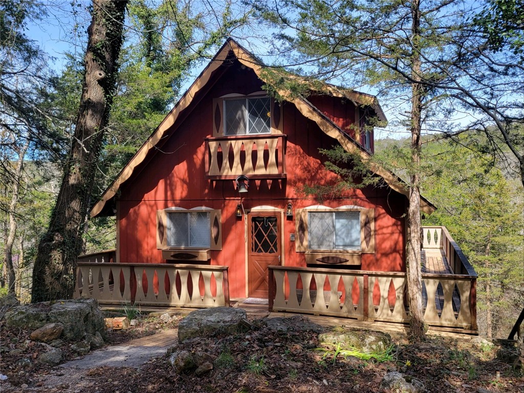 Charming lake front chalet featuring 3 bedrooms and 3 full bathrooms with a spacious deck to enjoy the great mountain views. There are sliding doors on all three levels to private decks. The main level has a cozy living area with a wood burning fireplace, lots of windows, dining area, u shaped kitchen featuring plenty of cabinet storage and counter space with access to the large deck and a bedroom. The upper level has 2 of the bedrooms (one accessing private deck) with a shared bathroom and the lower level has a spacious family room with wood burning fireplace with stone surround that leads out to a deck. Enjoy the meandering path to the waters edge right outside your back door.