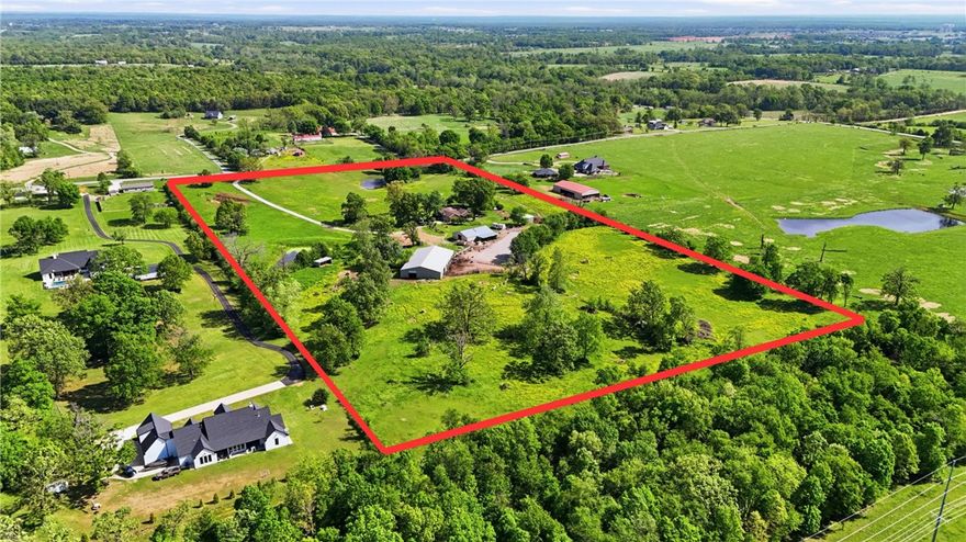Discover 20.5 acres in the highly desirable Bentonville School District, offering exceptional potential for development or continued equestrian use. Currently operating as an equestrian facility, the property features a well-equipped barn with six horse stalls, tack room, bathroom, and unfinished apartment ready for customization or added income. A charming farmhouse provides a great renovation opportunity, while a large shop offers ample storage or workspace. The expansive acreage and prime location in a rapidly growing area make this a rare investment opportunity for developers, investors, or those seeking a versatile estate. Endless possibilities await at this unique property in Gravette, Arkansas—create a private retreat, income-producing property, or future development.