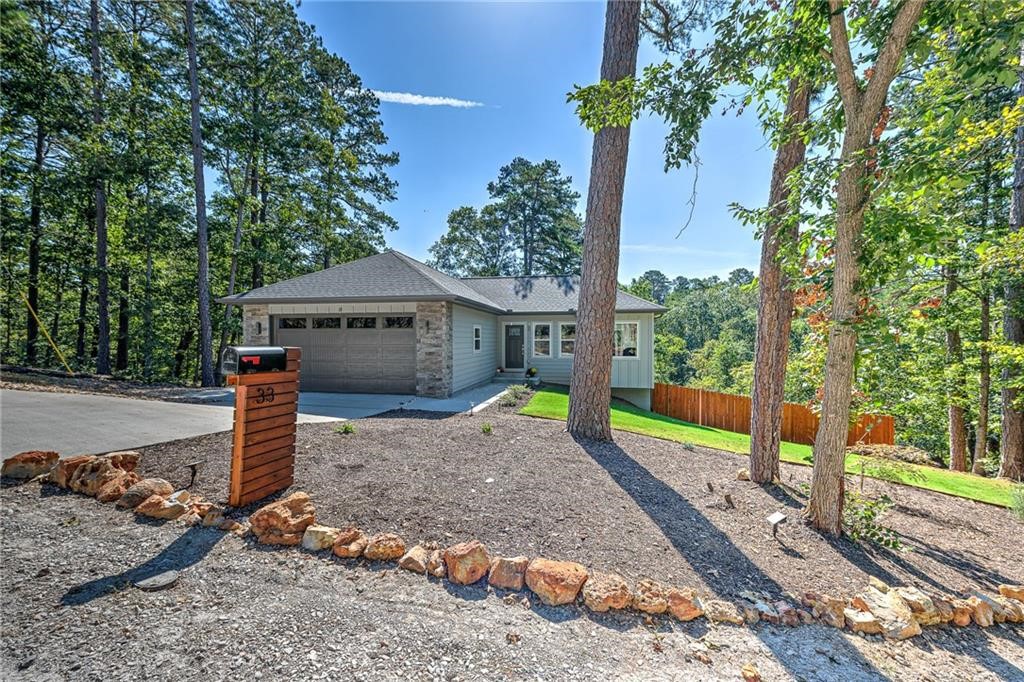 Open House this weekend - Saturday 1-3pm, Sunday 2-4pm. Welcome to 33 Shropshire Drive, a unique modern home built in 2020 and tucked away at the end of a quiet cul-de-sac on the east side of Bella Vista. Enjoy a private setting with wooded views out the back, while still being just 2 minutes from Highway 71 and only 20 minutes to Bentonville. This home features 4 bedrooms, 2.5 bathrooms, and two separate living areas, offering flexibility for family, guests, or a home office. The kitchen includes granite counters, modern cabinetry, and direct access to a deck overlooking the trees. Extras include: spacious garage with room for storage or workbench, upgraded 8ft tall garage door, outdoor shower / bike wash for easy cleanup after your rides, and a fully fenced backyard for pets or play. This listing (MLS 1323363) includes the home and it's 0.32 acre lot; it is also listed as the home and 0.32 acre lot plus an additional lot 0.32 acre lot (MLS 1323150).