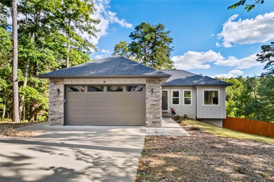 Welcome to 33 Shropshire Drive, a unique modern home built in 2020 and tucked away at the end of a quiet cul-de-sac on the east side of Bella Vista. Enjoy a private setting with wooded views out the back, while still being just 2 minutes from Highway 71, 5 minutes from Walmart and Harps. Bentonville School District. This home features 4 bedrooms, 2.5 bathrooms, and two separate living areas, offering flexibility for family, guests, or a home office. The kitchen includes granite counters, modern cabinetry, and direct access to a deck overlooking the trees. Extras include: spacious garage with room for storage or workbench, upgraded 8ft tall garage door, outdoor shower / bike wash for easy cleanup after your rides, and a fully fenced backyard for pets or play. Adjacent lot may also be available for purchase.