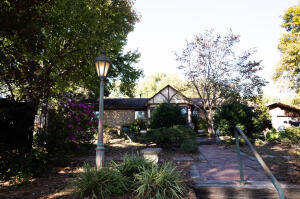 Cozy home nestled back in the beautiful gardens & is perfect for a family that loves spending time outdoors and that has a passion for horticulture. Travel past the gated entry to your own piece of paradise. Enjoy your very own seed room, green house and compost piles. In the back yard there are English gardens with each garden being lit, having electricity, drainage and its own water source. There are two water features that you can enjoy in the beautiful summer mouths. This beautiful yard has 2 out buildings and a detached garage. As you make your way in from the lovely gardens you find a nice 3 bedroom 2.5 bathroom home. This home has a formal dining room and sunroom to take in the rays in the winter months. The sunroom in included in the sqft and has a wood stove. Plus Storm shelter.