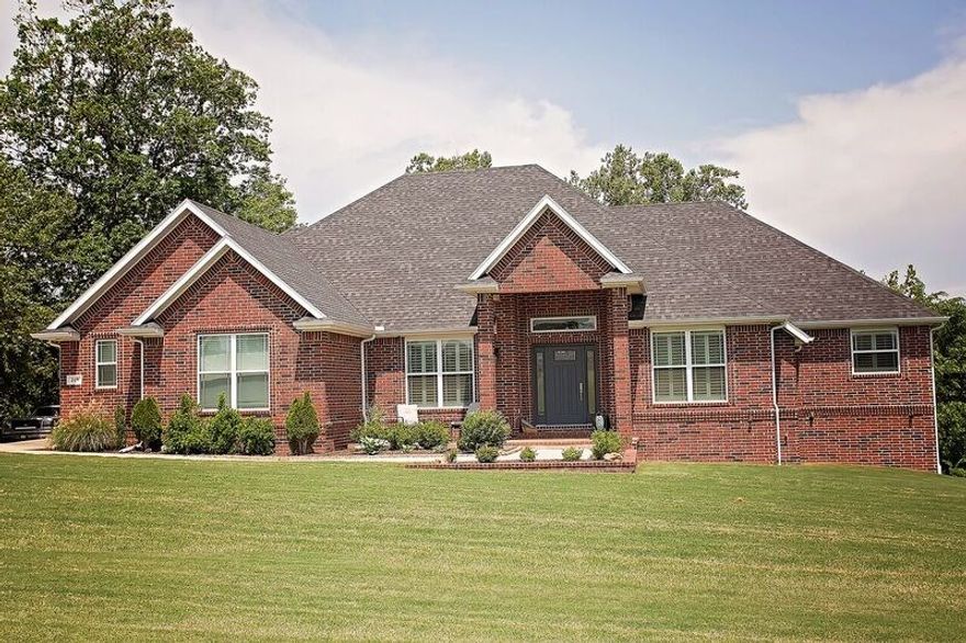 STUNNING CUSTOM HOME IN A DESIRABLE AREA ON 1.09 ACRE LOT IN BENTONVILLE SCHOOL DISTRICT. Luxurious features include 4BD/3.5BA, 3 car garage, designer kitchen, gas cooktop, granite, island, eat-in kitchen, formal dining, wood floors, wood burning insert w/ blowers, oversized master bath, mud room, plantation shutters upstairs, central vac, generator, walkout basement w/ kitchenette & game room, 2 utility rooms, Jack & Jill bathroom,  covered deck, community pool, & ample storage w/ lower garage, attic, & several closets.