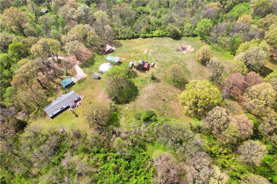 Don’t miss this rare opportunity to own a versatile property that merges the beauty of nature with
unbeatable convenience. Located in the highly sought-after Bentonville school district, this 6.7-acre parcel offers the ideal balance of privacy & accessibility. Just minutes from Hwy 112 & 264, I-49, I-612 & XNA, this haven features several potential building sites, including one currently occupied by a manufactured home. Whether you plan to establish a hobby farm, raise horses, or potentially construct your dream residence, this land provides the flexibility to bring your vision to life. Immerse yourself in the natural splendor and tranquility of the wooded surroundings with abundant wildlife for a peaceful retreat. Despite its secluded charm, the acreage remains well-connected to modern amenities. This exceptional offering combines the serenity of nature with urban accessibility—a blank canvas awaiting your dream retreat or expansion. Don't miss out--act today! See Residential MLS #1305282 and Land 1309728