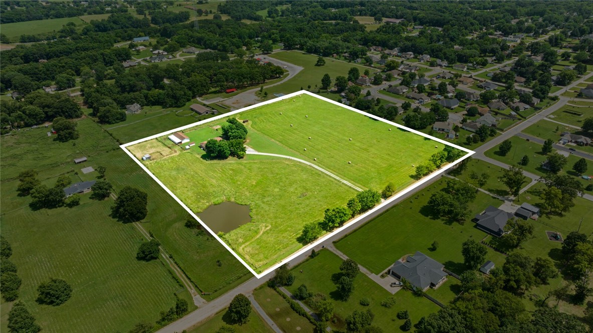This rare 10 acres is truly a gem...where rural charm & convenience combine. Adjacent to the city park and Pea Ridge city limits is south boundary. Bring the horses or know there is room to grow. Great potential to own a little piece of country close to everything in the booming town of Pea Ridge! The property includes a pond, fenced, flat pasture, outbuildings for all the toys & critters, and mature trees. Home is livable or awaiting your dreams: full brick exterior, 2 car attached garage, wood fireplace with brick surround in living room, eat-in kitchen, 3 bedrooms, 2 baths, laundry area off of garage entrance with sink & countertop and upper and lower cabinets for storage. Kitchen boasts lots of solid wood cabinets for plenty of storage space. Main bedroomĀ features an en-suite 3/4 bathroom with tile walk-in shower. Back porch is now a sunroom for extra living space (no HVAC). Close to Pea Ridge Schools, local amenities, & easy access to all NWA attractions!