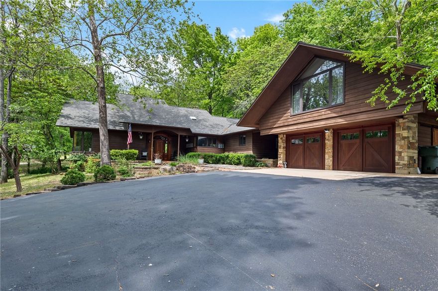 LOCATION! 3 secluded acres in town with private gated entry. 1 block off College Ave. 5 min from the square, and UofA, shopping, hospitals, and restaurants. Bordered by Brooks Hummel Nature Preserve and historic Skelton family cemetery, enjoy 20+ acres to explore with hiking trails just out your back gate. PRICE! Price improvement way below recent certified appraisal  Mid Century Inspired home with modern luxuries and superior craftsmanship. Custom cherry millwork, doors and cabinetry, dry stacked natural native stone inside and out. Vaulted ceilings, exposed timber with plenty of glass to let in natural light. Updated luxury master bath, kitchen upgrades, bedroom flooring, newer HVAC, this home is move in ready! Serene natural spring fed Koi pond, and naturally landscaped wooded grounds; a true oasis inside and out. Investment Potential: appt. suite above garage with private entrance- 2023 rental income of $24k. Heated & cooled 30x30 shop, 24x40 barn with RV plug. A must see to fully appreciate