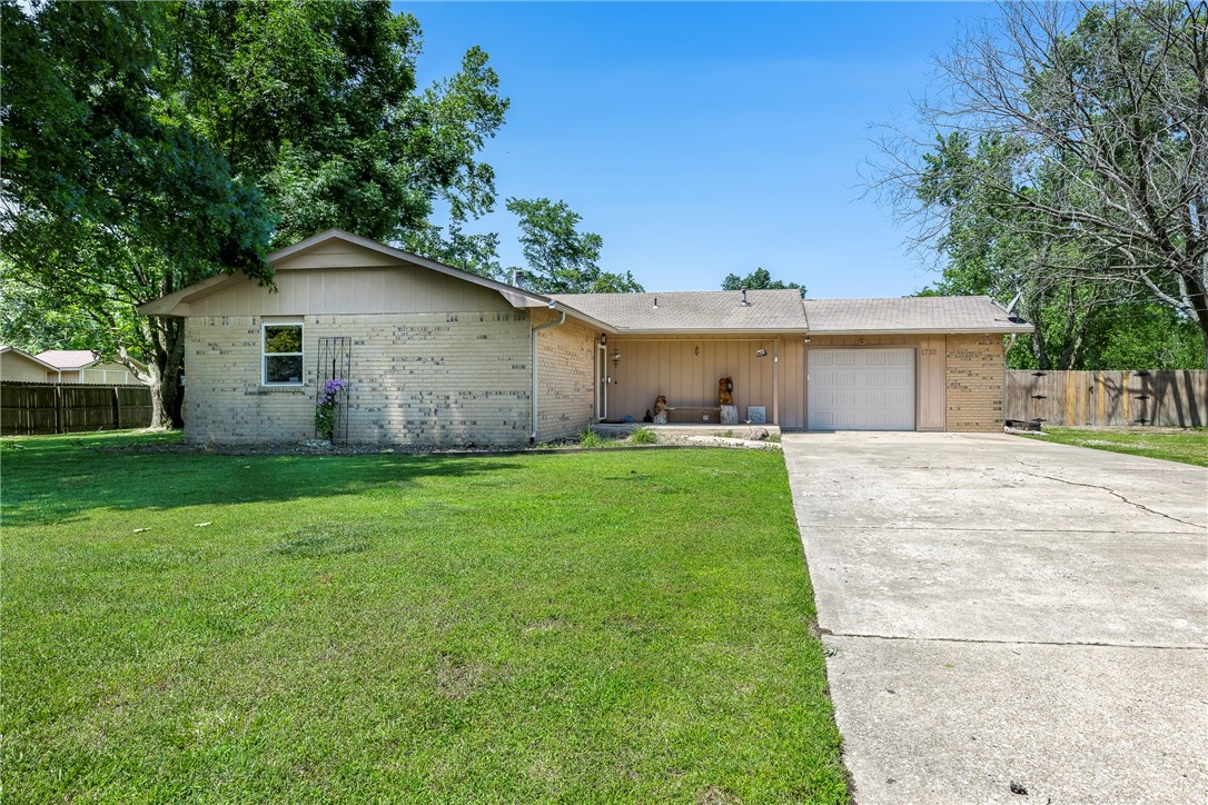 In the core of Bentonville, a hidden haven of rustic elegance awaits within the city's limits! This home, set on lush grounds spanning an acre, offers easy access to Downtown Bentonville and the serene Osage Park. This generous 3-bedroom, 2-bathroom home includes a versatile flex space, currently used as a 4th bedroom, but effortlessly transforms into a tranquil office retreat. Also has a four-season enclosed back porch. The street is a peaceful cul-de-sac, where children play, pets roam, and gardens bloom. The vast yard is a canvas for gardening, with a fenced area perfect for furry friends or feathered companions. A spacious shop awaits, ready to house an RV, boat, or other toys. The shop has a full kitchen, an a/c unit and a wood stove. A rare gem, this secluded acreage lies approximately 1 mile west of Walton Blvd., offering a sanctuary away from the city's bustle.