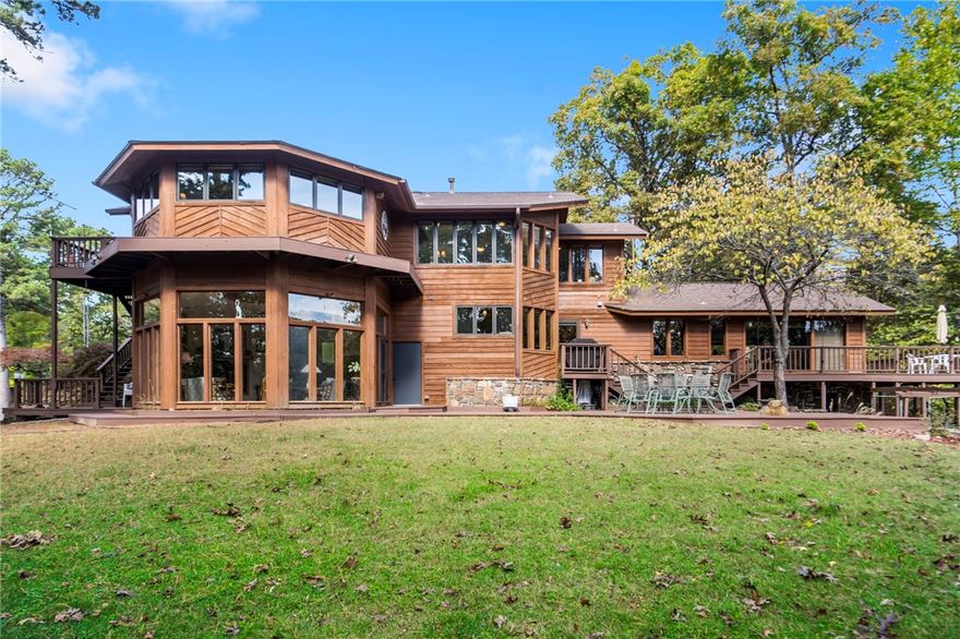 5 Beautiful acres so very close to Downtown Rogers and yet in every way a vacation feel.  The Precures designed, and personally built this home starting in 1976 and structurally completed the home in 1988.  This home design is inspired by the very best architects of our era. A labor of love in every nuance. The setting offers stunning natural beauty on all sides.  A gentle walk to your "hard-to-find" enclosed private boat dock with boat lift and swim deck. The home itself has so many special places for reflection and to enjoy nature. Designed with separate quarters or "wing" for extended family or visitors. This is the place you have always dreamed of calling home.