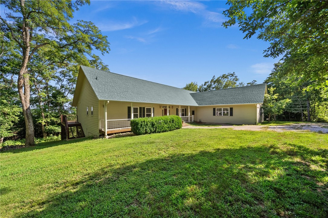 Perched on a hill above Beaver Lake amidst 23.61 acres of Oak and Pine trees, this secluded home reveals an amazing view of the lake. The split floor plan offers dual main suites, which makes this home perfect for families who want everyone under one roof. 2 bedrooms, full bath, and kitchenette afford guests or mother-in-law with a little more personal space than a traditional guest room would allow. You will find the Primary bedroom, bath, half bath within the 3115 sq. ft. on the main floor. The living room has picture windows spanning the entire wall giving you a sunfilled living, dining room, and kitchen. The living room also boasts a beautiful wood burning fireplace that you can cozy up to on chilly days. The nicely equipped kitchen and spacious laundry room with washer, dryer, and shower complete the main floor. Stairs down lead to 3115 sq. ft. of heated, cooled, and plumbed unfinished walkout basement ready for your desired use. The shop area of the basement has a wash basin and toilet for your convenience.