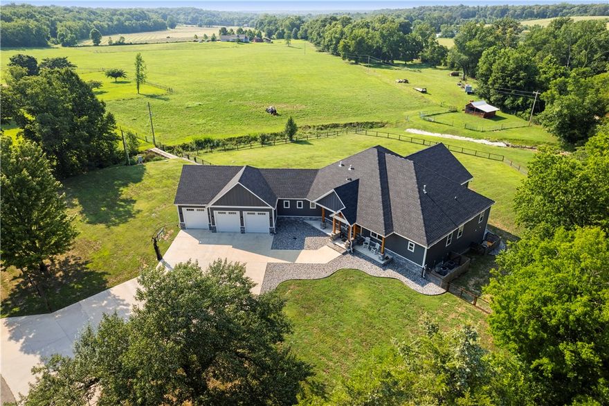 Charming home on 13.8 acres would make a perfect hobby farm where you can tend to cattle & horses. Picture a tranquil setting on Spavinaw creek that flows year-round, inviting you for a swim in the warmer months. You will see stunning 22-ft vaulted ceilings highlighting the beautiful outdoor views of the Ozarks. The screened in back patio adds charm, providing a perfect spot for year-round enjoyment.
The home provides luxury and comfort with its primary suite and additional 3 bedroom each w/ensuite bathrooms and office on the main level. The kitchen is a cook’s dream with its top-of-the-line appliances & walk-in pantry w/custom designed built ins.
Entertain your friends in this one-of-a-kind basement w/ darts, pool, dancing, parties & more. A full bar with prep area that includes sink, dishwasher, refrigerator, & ice maker. It offers 1 bedroom, 2 full baths, dog bathing station & stunning walk-in safe room. 
This home offers the perfect blend of rural charm and modern comfort. See commercial MLS 1264135