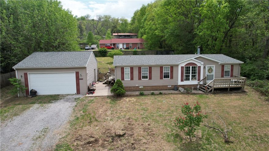 Directly behind the old Ozark Mtn. Smokehouse in Fayetteville, and next to the Mt. Kessler MTB trails, this property could have great opportunities for somebody in the mountain biking business or a related business.  The mobile home is on a permanent foundation and will have the title cancelled through the process.  Though it likely will not pass requirements for FHA or VA, this might go conventional loan.  The seller will not do any repairs, or credits for repairs, or complete any 3rd party requirements.  Make your offer to accept the house as-is.