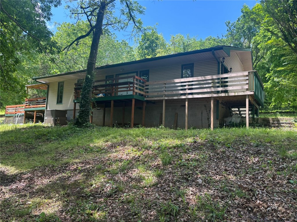 Own a truly unique piece of history! Originally built in 1970 as Thunder Mountain Church, this remarkable property has been lovingly converted into a spacious 4-bedroom, 2-bath home. Set on 2.64 acres of serene, private land, it offers a peaceful escape with the convenience of being close to Fayetteville. Step inside and discover the original entry doors and 2000 sqft of flexible living space. The interior walls are not load-bearing, providing an incredible opportunity to redesign and create your dream home. The kitchen boasts beautifully refinished original hardwoods to ensure comfort and peace of mind. Enjoy morning coffee with stunning back porch views, surrounded by nature, or cultivate your grand garden. It's the best of both worlds – tranquil country living with easy access to all the Razorback festivities and Fayetteville's vibrant dining and activities!
