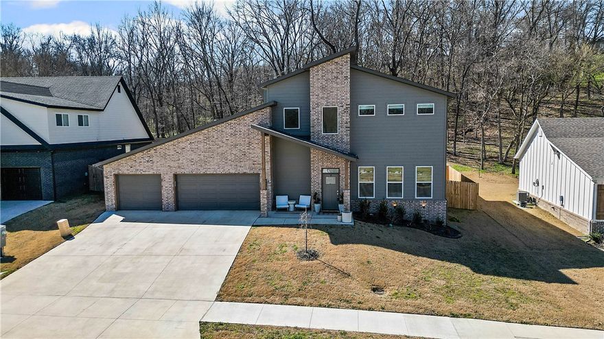 Discover this gorgeous upscale modern home that feels better than new, styled with warm, elevated details throughout. Located in the Big Sugar golf community, with the golf course just a short walk away. The gourmet kitchen features a unique wrap-around layout with an open island and a concealed prep area behind the main wall, offering added cabinetry, counter space, and excellent storage while maintaining a streamlined look. Custom bamboo shades soften the natural light, and vertical shiplap accents add sophistication in both the foyer and the primary bedroom, where upgraded plank flooring continues for an inviting feel. The upstairs bonus room can serve as a 5th bedroom and includes its own custom shades. A covered patio opens to a welcoming backyard for relaxed outdoor gatherings, and the 3-car garage adds valuable convenience. Located in the Rogers School District just minutes from Pea Ridge, downtown Rogers, and the Home Office. Come explore the space and picture the memories waiting to be made!