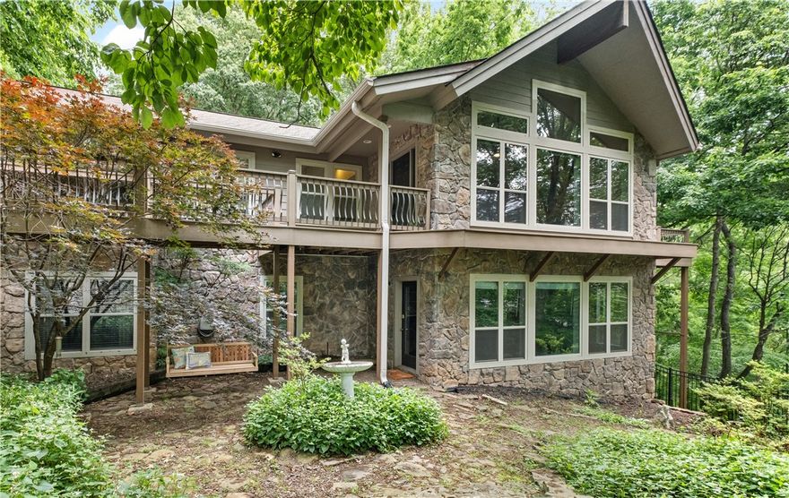 Stunning newly renovated Stitt energy-efficient lake home has all the stylish features you want and includes a boat slip/lift in the community dock. The open living area has beautiful wood floors, vaulted ceilings, a woodburning fireplace and south facing windows. The kitchen has custom cabinetry, quartz counters, decorative tile, stainless appliances and a large butler's pantry. Vaulted ceilings continue into the main bedroom and the bath's shower features dual showerheads and a floating bench seat. A half bath and laundry room compete the main floor. The lower level has a family/game room with a wet bar. Three large bedrooms, two baths and a smaller bonus room complete the floor plan. There's an attached three-car garage and a detached two-car garage with livable space above including a half bath. The community boat dock is easily accessible by a concrete path. The boat slip with a lift will accommodate a tritoon boat and there's a metal storage locker. Golf cart conveys. Only seven minutes to downtown Rogers.