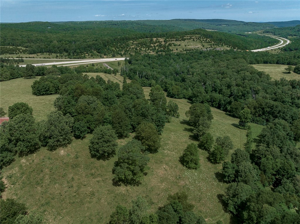 Scenic 61.30 acres in Winslow next to I-49. Unlimited opportunity for development, residential, agriculture or commercial use on 2 parcels. Mostly fenced with paid water taps and 3-phase electric. Paved, county road access with 2 ponds and a creek. Varied terrain with pasture and woods. Includes 3-bay metal shop building and retired chicken house. Vacant mobile home negotiable. Recent survey and positive soil tests. Convenient location – 20 mins to Fayetteville and 30 minutes to Fort Smith. No deed restrictions or covenants.