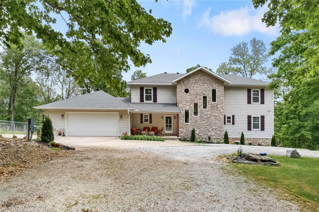 Welcome to your secluded home on Esculapia Hollow Road. Minutes from the excitement of Downtown Rogers and a stones throw from the nearest Beaver Lake access point, this property could not sit in a more convenient location. Supermarkets, parks, trails, restaurants, music venues, and all of the amenities of city living are all nearby. Begin your mornings with a sense of bliss as you savor your coffee on the expansive back patio, comforting front porch, the tranquil sunroom, or even the dining room where the large windows offer a treetop view! Enjoy 4 bedrooms complete with 4 full bathrooms, with suites on both the main level and upper levels. You will love the primary suite, with a massive closet and a luxurious bathroom with double vanities, a soaking tub, and a zero-step walk in shower! You won't want to miss this executive style home in Rogers. Schedule a showing today! ADDITONAL ACREAGE AVAIALBLE IF YOU NEED MORE SPACE AND USABLE LAND!!!
