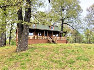 Spacious log home with over 3,000 sq ft nestled in the beautiful Ozark hills. This home is in a prime location, just minutes from the Erbie and Pruitt access on the Buffalo River, and the Buffalo River National Park, yet just a short 15 minute drive into Harrison. With a parklike setting and 14.45 acres m/l, you'll love the location and the gorgeous view of the mountains. A perfect place for horses, with a nice mix of pasture and woods. 2 large covered porches to enjoy the peacefulness. Lots of room inside, with 4 bedrooms , 3 full baths, recreation room, den , and spacious kitchen w/ separate dining room. 30 x 40 insulated building with overhead door, Large deck with hot tub, organic garden and lots of wildlife.Room sizes approx., sq ftg per assessors office. Seasonal pond.