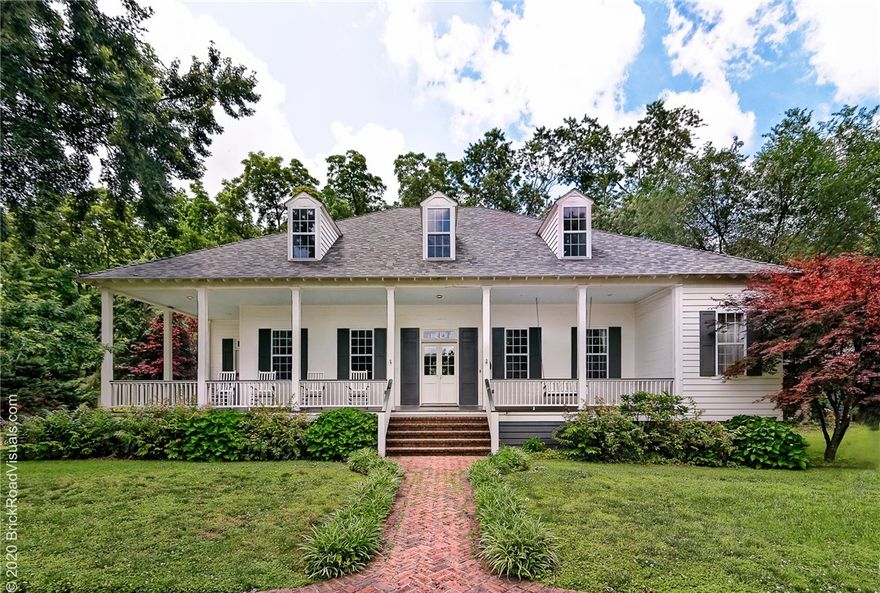 Gracious and refined, this Louisiana French colonial home situated on a quiet, downtown Bentonville street impresses at first sight. Large covered porches, mature trees, and lush landscaping invite one inside to glide across stunning, reclaimed pine floors throughout. Enjoy reading by dappled sunlight through the bank of family room windows. The updated, eat-in kitchen is the perfect room to cook a family meal or entertain guests. A spacious main level includes the master suite and second en suite bedroom. Up the private stair to two oversized bedrooms adjoined by a jack-and-jill styled bathroom, an open bonus room, craft room, and conditioned storage room. Walk or bike to the picturesque Bentonville square, nearby top-rated public schools, museums, and trails.  This home boasts many loving memories and promises to make more for your family too.