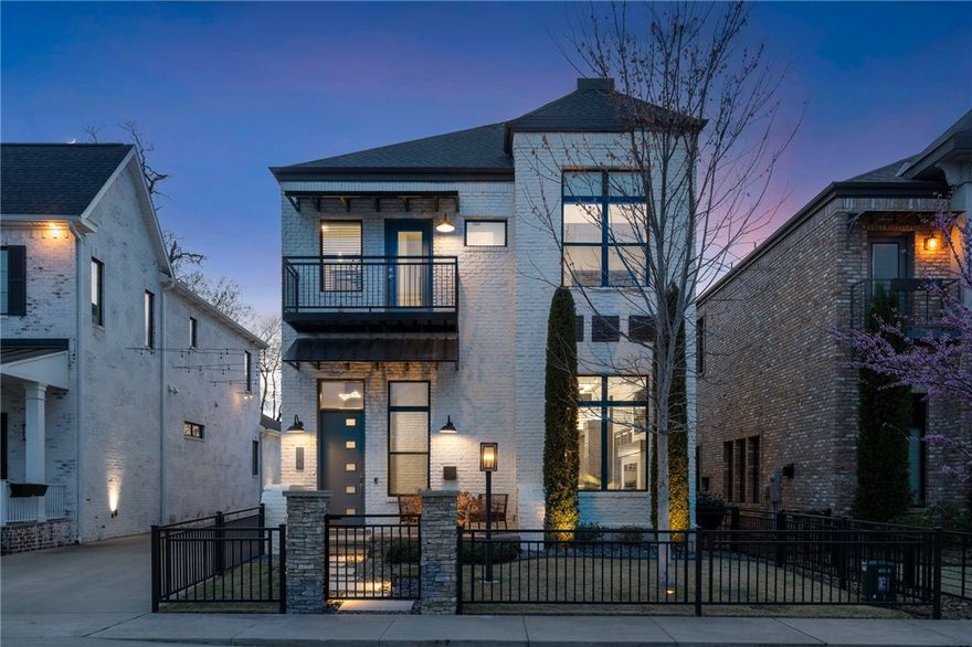 Nestled in downtown Bentonville, just three blocks from the Square, 232 SW D Street is a stunning blend of historic charm and modern luxury. Built from white-painted Old Chicago brick, the home features soaring 12-foot ceilings and expansive windows that flood the space with natural light. The state-of-the-art kitchen is a chef’s dream, complete with gourmet appliances, a custom bar, and exquisite finishes. The main-level primary suite is a private retreat with a spa-like bath, dual sinks, a soaking tub, a walk-in shower, and dual closets. Upstairs offers three spacious guest bedrooms, two full baths, and a media room designed for relaxation. The entertainer’s backyard is a curated oasis with a heated soaking pool, cascading waterfall, floating water feature, fire-lit pergola, and a full outdoor kitchen with a bar. A detached two-car luxury garage with outlet for EV charger completes this exceptional home, just minutes from Crystal Bridges, The Momentary, world-class dining, and scenic biking trails.
