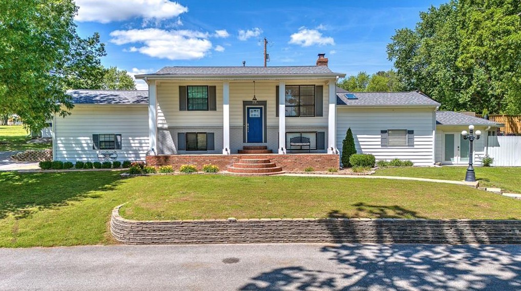 Sitting on almost 1 acre just minutes from Promenade Mall, Pinnacle Area Entertainment, and much more, this is a rare find in NWA. Bright and spacious split-level home with hardwood floors, new paint, and updates throughout. Living space is open to the dining and kitchen area, great for entertaining. Kitchen has granite, stainless appliances, gas cooktop and plenty of workspace. Large windows overlook the backyard and pool. Two guest bedrooms and fully remodeled guest bath on main level along with a bonus room. Lower level features a cozy second living room with fireplace. Updated flooring throughout lower level. The primary bedroom is a true retreat with large sitting area space and private backyard views. Primary bathroom has huge walk-in shower, great storage and vanity space. Home office space on lower level and access to the 2-car garage. This lower level could be a full owners retreat! Outside is your own oasis tucked away in town with a private in ground pool! Detached garage offers workshop/extra storage.