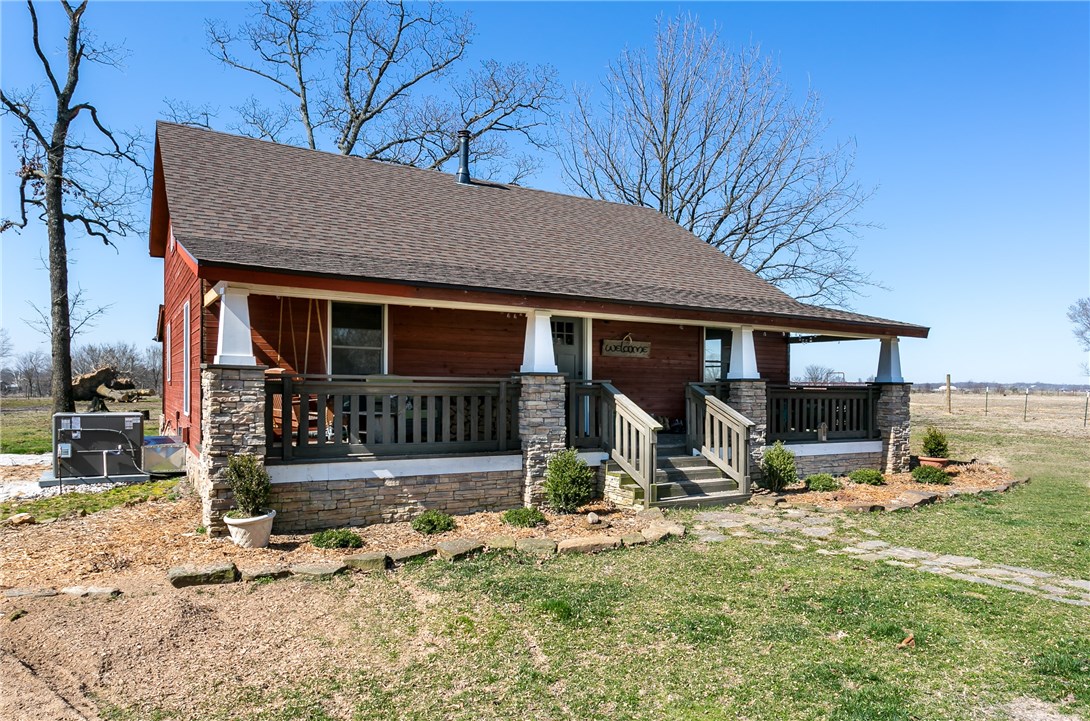 A rustic charmer. The pine tree lined drive leads you to this home sitting on 4 nice level acres with so much to offer. The living & dining room boasts high ceilings with exposed wood beams, & a gorgeous native stone accent wall that is the back drop for the wood stove you will want to cozy up to. The open kitchen offers stainless appliances, & granite counter tops.The master is on the main level, with 2 beds on the 2nd level. The home has two wonderful covered porches for sunrise & sunset enjoyment.A shop and a very nice Horse barn with horse stalls round out this great property.
