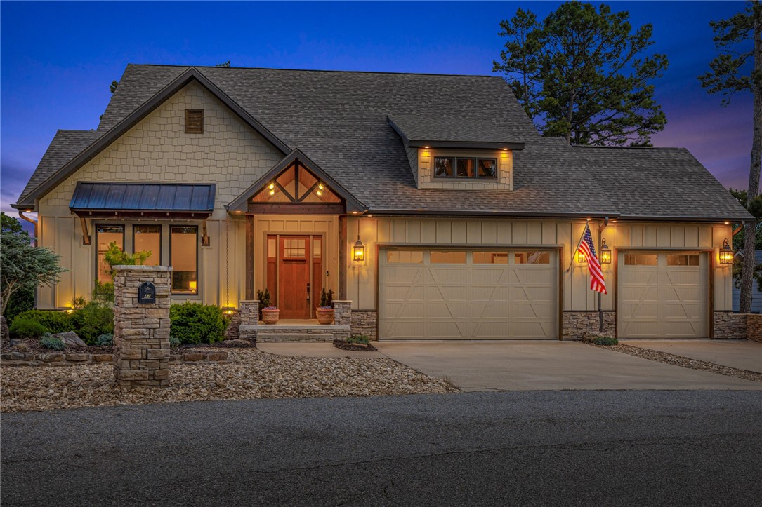 Stunning lake front craftsman home! Meticulously built w/high end features throughout including, wood floors, cedar beamed raised ceilings, granite counters & large windows. Guest suite located to left of foyer with custom barn door, full guest bed & bath along with access to main level laundry room. Living area boasts a stunning stone fireplace and is open to kitchen/dining, perfect for hosting. Kitchen features large island w/counter seating, custom cabinetry & lighting, gas range & more! Dining space has access to the spacious upper-level deck w/ amazing views. Primary suite is a true retreat, w/spa-like attached bath & deck access. Lower level is an entertainer's dream! Featuring a dual sided fireplace, built ins & kitchenette space. Guest bedroom on lower level along with a full guest bath with stackable laundry hookup. A hidden bonus room is a great additional space! Lower-level covered deck offers additional outdoor living space, with access to your grass courtyard & paved walkway right to your private dock!