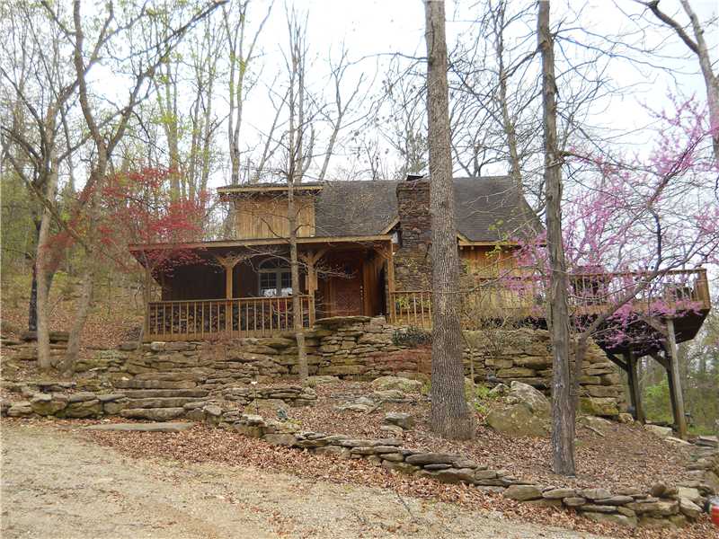 Approximately 1072 Ft of Lake front Corp Line. Darling bat and board sided cabin with an enormous deck for lots of outside living. Located on Henry Hollow Arm of Beaver Lake. 3 slip community dock with large play area, electric , Boat & waverunner lifts.,The cabin has an awesome rocked wood burning fireplace with gemstones embedded. Open floor design with a loft . Natural cedar railing . Enormous windows. Covered front porch. Beautiful stacked rock stairway leading up to the porch & lovely landscaping.