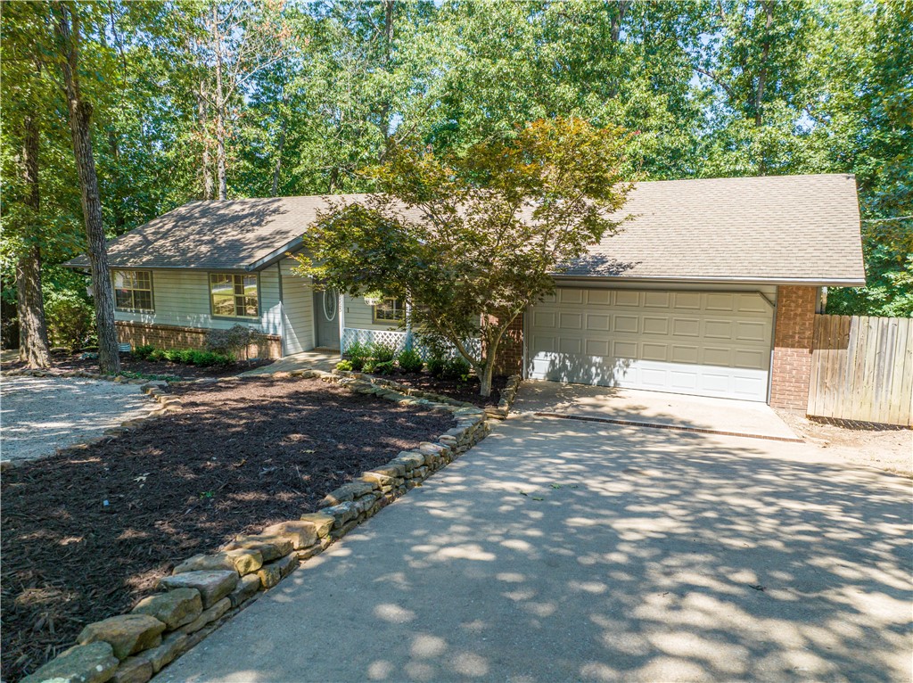 Welcome to this charming home nestled near Beaver Lake! This inviting residence boasts 3 spacious bedrooms and 2 full bathrooms, ensuring comfort and convenience for all. The galley kitchen and breakfast space offer a delightful atmosphere for preparing and enjoying meals, while the large living room with a wood-burning fireplace creates a cozy ambiance. Step outside onto the nice-sized deck and relish the serene private view, perfect for entertaining or relaxing. With a 2-car garage, you'll have ample parking and storage space. The combination of carpet, tile, and wood vinyl flooring adds both style and durability to the home. Situated on a peaceful cul-de-sac, this property presents a tranquil retreat near Beaver Lake. Property is also wired for an invisible fence. Don't miss out on this opportunity to make this house your home!
