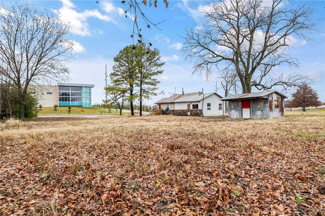 This property stands out for its flexibility—whether you're thinking commercial, residential, business in the front & residential in the back, or multifamily, the options are wide open in a high-growth corridor Just minutes from XNA Airport, the Walmart Distribution Center, and Downtown Bentonville, it's ideally situated in a fast-growing area surrounded by neighborhoods, apartments, and warehouses. Zoned agriculture; all development plans and sewer tap access must be confirmed with the city. This is a rare chance to shape a space that fits your vision. House has NO Value, Not Livable, property is sold as-is. Preliminary design layouts for the property are attached.