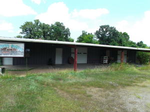 Very nice 50'X 80' building with 20 X 80 overhang. Has a kitchen, bath and office area. 2 Roll up doors & 2 Entry doors. Good hard surface parking area. Property also has 2 rental houses that can be sold separately but would like to be included in the 5 acres. Formally the Pittsburg Auction Barn.