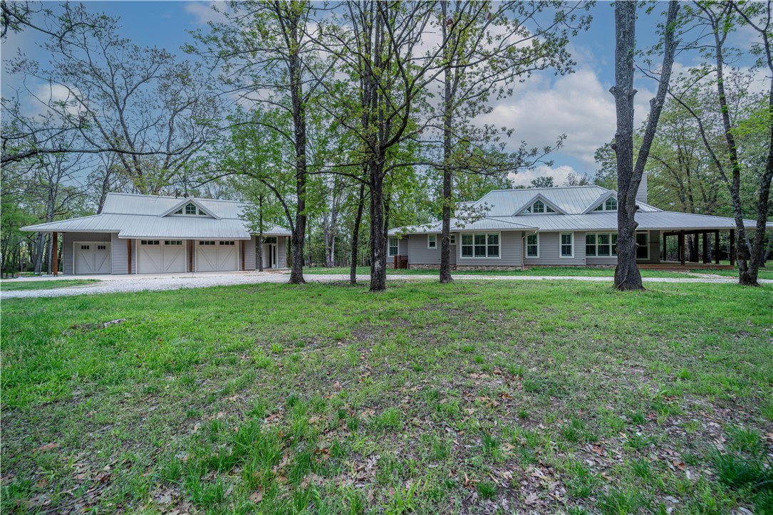 Experience elevated luxury on beautiful Beaver Lake. This exceptional 2,475 sq ft residence offers 2 bedrooms, 2.5 baths, and a detached oversized garage featuring a private guest suite with full bathāperfect for hosting in style. Crafted with premium materials including LP Smart Siding, seamless metal roofing, a whole-house generator, storm shelter, and closed soffits for lasting peace of mind. Exposed cedar on the wrap around porch, timeless plantation shutters throughout, and a screened-in lounge that frames lovely lake views. The formal dining room and open-concept living space offer an elegant setting for entertaining. All bedrooms are ensuite, with a luxurious primary suite showcasing a spa-caliber hydrotherapy ozone tub. A chefās kitchen awaits with gas range/air fryer combo, drawer microwave, breakfast bar, and all refrigeration units included. 2.1 pristine level acres with underground pet fencing, dual RV hookups, and a short stroll to the community dock with boat slip and swim platform.