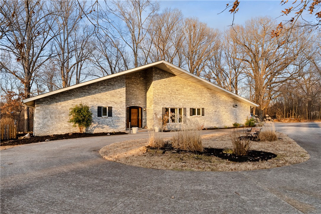 Welcome to the coolest house in Benton County. As you enter through the gate, you will follow a paved blacktop driveway through a beautiful 7.5 acres that leads to the house sitting at the back of the property. Upon entering the house, your imagination can take hold making this home unparrelled to anything in NWA. The fresh paint and brand new carpet are evidence of a home well loved and well cared for. Now it's time for your touch. The home boasts tons of opportunity with its 2 bedroom/3 bathroom layout with large office and workshop in the garage. And don't miss the lovely sunroom that leads to a cozy back deck. A truly wonderfully built home that feels sturdy the minute you enter. As you walk the property, you will find various shops and barns and even an additional mobile home that could possibly be used as a guest house with some work. This is an opportunity that doesn't come along often. Owning this much land so close to town is something you've been waiting for! Ask for the QR code to see the video