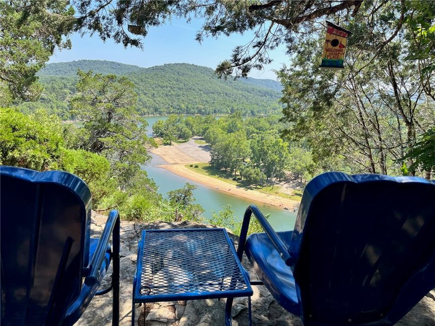 Perched above Tablerock Lake and designed to highlight the panoramic views, this stunning property offers contemporary architectural design and artisan finishes in every space. Inspired by the traditional Ozarks "dog trot" cabin, this modern version provides primary living quarters & separate guest space connected by the entry breezeway. The main portion of the home is true timber frame construction, built of pegged, hand-hewn hardwoods. The stylish interior is warmed by burnished wood, custom built-ins & eco-friendly bamboo flooring, highlighted by the window wall & expansive view. The guest wing includes kitchenette and 2 bedrooms with connected bath. The 3rd level perch offers a unique bonus room with more big views. Outdoors, enjoy beautiful rock gardens, or relax on the breezy screened porch, open deck or bluff-side patio. Additional special features include an elevator, whole house generator, basement level studio & storage. This home is more than just a beautiful place to live – it is truly a piece of art.
