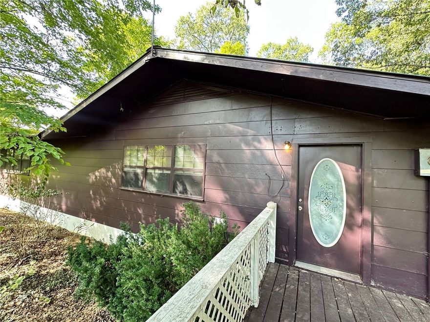 Tucked away at the end of a quiet country road this private retreat is surrounded by 5.89+/- acres of mature trees. Spend your mornings on the sunny deck with a cup of coffee or wander the property's outbuildings-including a handy storage shed with fenced area for pets and an open-air barn that's perfect for a chicken coop, workshop, or garden shed. The property also features several fruit trees and an additional slab with utilities and septic where a home once stood. Inside you'll find an inviting open living and dining area, 3 bedrooms, 2 bathrooms, and a spacious kitchen, with its warm wood countertops, roomy pantry, and included appliances. The oversized primary suite is a true retreat, complete with a walk-in closet and a spacious bath designed for comfort. Central heat and air, along with a ducted wood stove system, keep the home cozy in every season. Nestled in the heart of the Ozarks and just minutes from thousands of acres of National Forest this property is the country life style you've been waiting for.