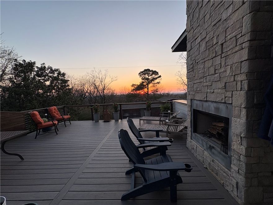 Gorgeous, breathtaking views greet you daily from the 500 SF rooftop deck, complete with a wood-burning fireplace and sweeping sunset views across Fayetteville—an exceptional space for entertaining or unwinding. Inside, the living area centers around a fireplace, with natural light pouring through a wall of windows. The reimagined kitchen, thoughtfully designed within the home’s original footprint, flows seamlessly and is ideal for any cook. A custom-built nook, perfect for pets or kids, showcases repurposed original flooring as a unique architectural accent. Main level features a private primary wing with western views, two walk-in closets, dual vanities, integrated laundry, and tiled walk-in shower. A second bedroom or office and an additional full bath complete the level. Upstairs, a light-filled landing with kitchenette connects two bedrooms and a full bath with original 1935 cast-iron tub and bonus space adds flexibility. The backyard preserves the stone foundation of the original homestead and a 2 car garage.