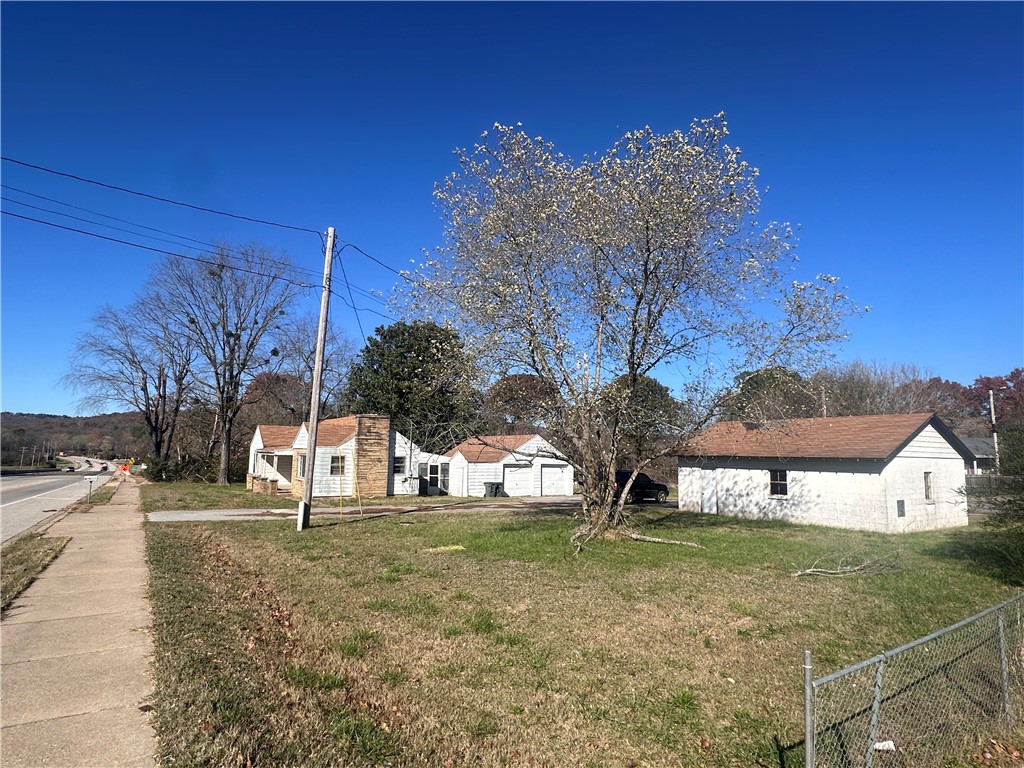 This 0.975-acre lot, located just 10 minutes from the University of Arkansas and 8 minutes from Downtown Fayetteville, sits in one of the fastest-growing areas of the city. With RMF-24 (Residential Multifamily) zoning, allowing up to 24 units per acre, and significant highway frontage, this property offers outstanding development potential. It is ideal for a multifamily or townhome project, taking advantage of the high demand for housing in this vibrant area. Additionally, the property features an older home and a detached garage, both of which could be renovated to provide immediate rental income while the development is underway. The property is situated in a rapidly evolving area with proximity to major highways, commercial centers, schools, and parks, making it a highly attractive option for future tenants. With its prime location, zoning flexibility, and strong growth potential, this property is a rare find for developers and investors alike.