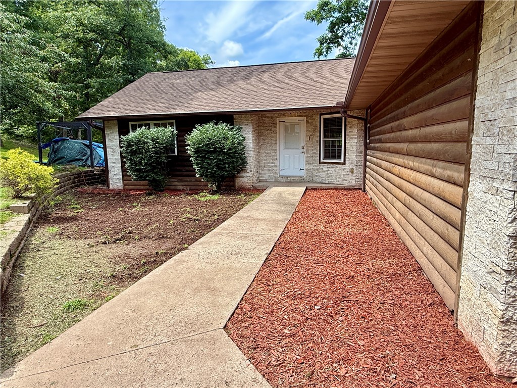 Charming log-sided home located in the peaceful Monte Ne Shores area, directly across the road from Beaver Lake. This 3-bedroom, 2-bath home sits on 1.66 acres, comprised of three parcels, and offers a winter lake view with partial views year-round. The property is privacy fenced and features a large deck overlooking the yard, perfect for enjoying the quiet, natural surroundings. The deck is wired for a hot tub, making it ideal for future upgrades. Inside, you’ll find rustic tin walls and decorative rock accents in the living room that add unique character. The home includes a two-car garage with keyless entry and well-maintained landscaping with fresh mulch recently added. While the home does need paint and new flooring in the living area, it presents a great opportunity to add your personal touch and turn it into your dream lake-area retreat. With its spacious setting, charming features, and proximity to the lake, this property offers both comfort and potential in a beautiful location.