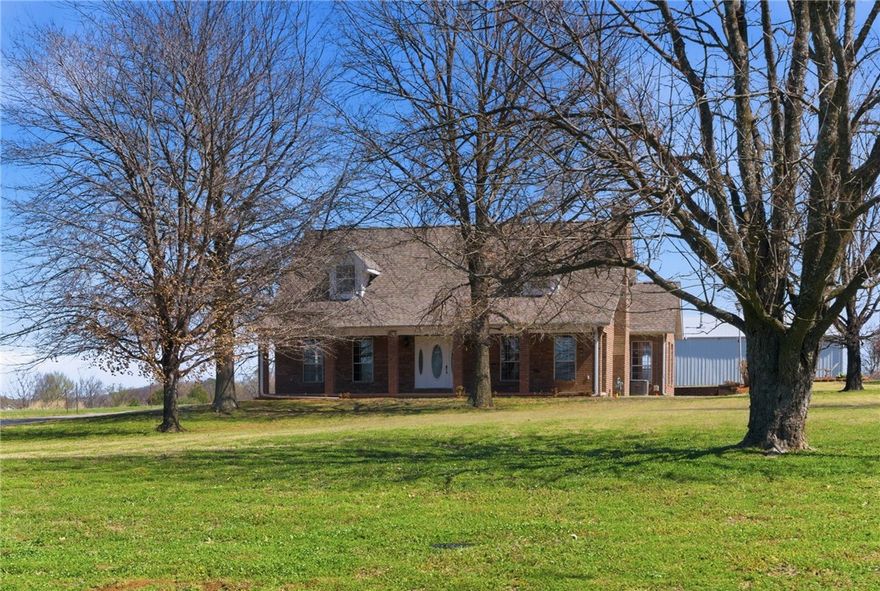 First time on the market! Unique opportunity to own a one-owner custom home on 3 acres in Fayetteville. This traditional country home features 3 bedrooms with the primary suite on the main level, bamboo flooring, a wood-burning fireplace, eat-in kitchen, and a bright sunroom perfect for an office or sitting area. Upstairs offers a large bonus room with barn-style ceiling and private deck access, providing potential for a fourth bedroom or flex space. New carpet installed March 2026. The property also includes an insulated 1280 sq ft metal shop with electricity (110 & 220) and rough in plumbing. Enjoy a peaceful setting with mature trees and open land from your covered front porch, sunken patio or deck. Just ~4 miles to the University of Arkansas, Dickson Street, and Interstate 49. New roof 2021. Up to $6,000 closing costs paid with preferred lender. Carport conveys.