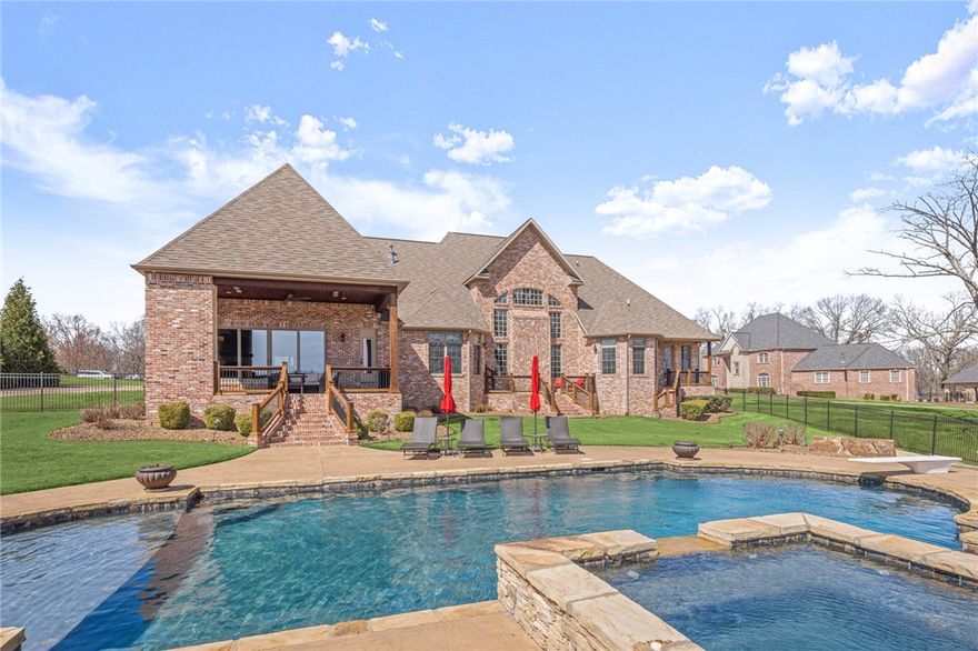 Stunning 2016 Estate Home on 6.83 Acres in Talamore Community, Bentonville. The home features a saltwater pool, private pond, pool house building, as well at 5,593 sf home. Home features hardwood floors, interior brick detail, vaulted ceilings & beams and more! Formal dining and a home office off entry. Large living room with fireplace opens to the spacious kitchen boasting large island, 6 burner gas stove, pot filler, and built ins. Main level bonus room has stone fireplace, wet bar, and access to outdoor living area. Outside enjoy the privacy of 6+acres from the covered patio with outdoor kitchen & fireplace, lounge by pool or in hot tub & enjoy views of the pond & dock. Primary suite has extra room for gym/study & huge attached bath with walk in shower & soaking tub. Upstairs is 3 en-suite guest beds, sitting area & desk space & 500sf attic storage! Pool house has dog wash area, tankless HW & can be finished out or used as shop space. 3 car garage & cul-de-sac setting. Welcome Home!