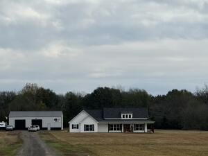 43 acres of picturesque land, this stunning 2 1/2-year-old home is a true sanctuary for those seeking space, privacy, & modern comforts. The property boasts a serene pond brimming with fish. Cozy up by the fireplace during chilly evenings & relish in this 3 bedroom / 2.5 bath home. Itself showcases contemporary design, featuring foam insulation for optimal energy efficiency and an 18 SEER HVAC system to ensure comfort throughout the seasons. Safety and security are paramount, with security system, a secure gated entrance, and a fortified safe room designed for peace of mind. The impressive 40 x 60 shop with 12-foot walls offers endless possibilities for hobbies or storage, complete with separate electrical service for added convenience.