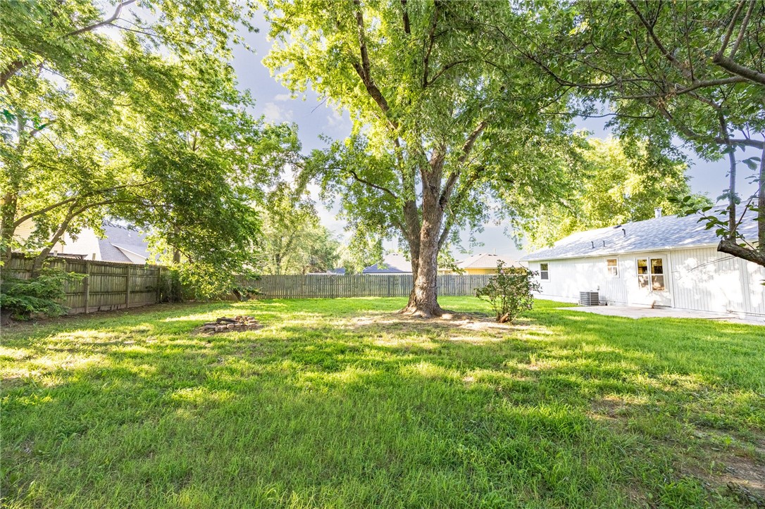 Welcome home to this charming property just minutes from thriving Walmart HQ. This 3 bedroom and 2 bath residence boasts 1098 sq ft. It sits on a sizable .37 acre lot with a freshly painted exterior. The interior also has an updated color scheme. There was a new roof added in 2024. This energy efficient home has solar panels that have been all paid for by the seller.. The seller is also providing a home warranty to insure a peace of mind! " Don't miss the opportunity to experience this wonderful home for yourself! This home is actually zoned for Benton County- not city zoned. Possible additional ADU on property up to 525 Sq ft- tiny home.