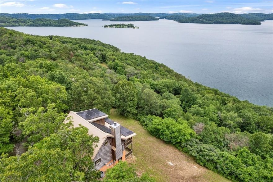 This stunning +/- 2,480 SF luxury cabin home offers breathtaking views of Beaver Lake and the perfect blend of comfort and rustic charm. Nestled just 1.3 miles from the nearest boat ramp and 12 miles from Eureka Springs, this beautifully designed home features 3 spacious levels and 4 beds/2 baths. The main floor includes a living room with a fireplace and balcony access overlooking the lake, an eat-in kitchen, and a primary bedroom (with jacuzzi tub) that also opens to the balcony and a full bathroom. Upstairs, a large loft overlooks the living room and can serve as a bedroom. The walk-out basement level features a large family room with deck access, 2 bedrooms-one with deck access-a full bath, and a washer/dryer. Throughout the home, you'll find vaulted ceilings on the main floor, hardwood floors and luxury vinyl plank flooring for a stylish yet durable finish. Whether you're relaxing on the deck or the balcony, this lake view cabin is the perfect place to unwind and enjoy the natural beauty of Beaver Lake!