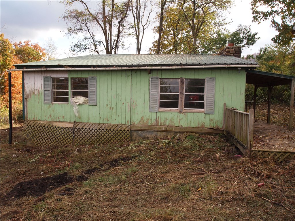 Nice rural location with older home that needs some TLC. Approx. 1.48 acres with potential views. It's a beautiful drive to the home through the valley. Solid metal roof, some small outbuildings, utilities on site. Arvest employees, board members, and their immediate family members are not eligible to purchase Arvest Bank owned properties. Property to convey by Special Warranty Deed. Buyer to verify school and utility information. See attached legal description.