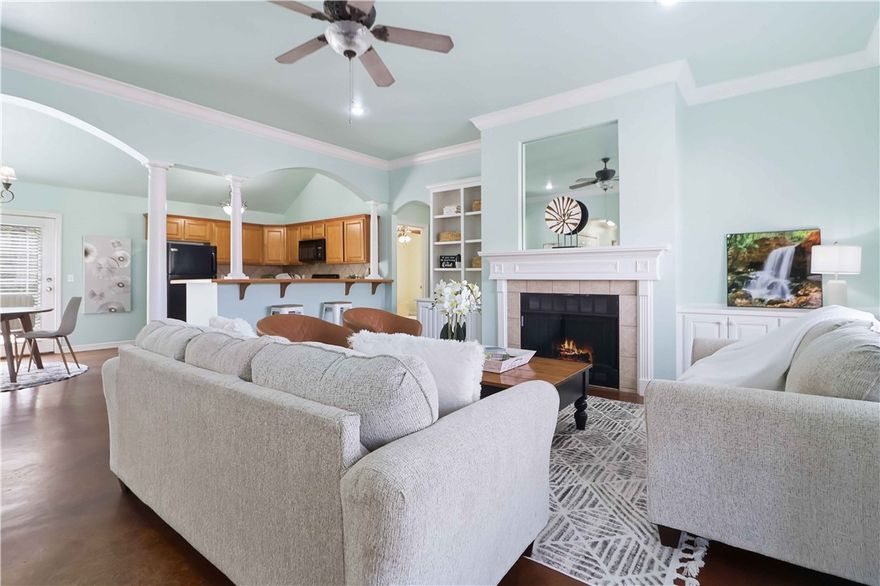 Dang cute doesn’t even begin to cover it! This thoughtfully designed 1,689 sq. ft. home feels peaceful, welcoming, and lives much larger than its footprint. Featuring three bedrooms plus a versatile bonus room with French doors and a closet, this flexible space can easily function as a fourth bedroom, home office, second living area, or creative studio. (I’ve even sold this exact floor plan where the bonus room was perfectly used for in-home daycare services!)

The open-concept living area flows seamlessly into the kitchen, showcasing built-ins and a cozy wood-burning fireplace that anchors the space. Stained concrete floors throughout the main living areas offer both style and easy maintenance, while brand-new carpet has recently been installed in all bedrooms for added comfort. Every square foot is utilized beautifully, creating a home that feels spacious, functional, and just plain happy.