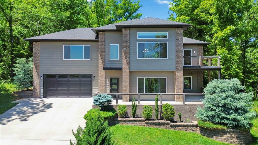 This stunning EAST Facing, LAKE-VIEW home offers a unique and flexible layout just 4 minutes from Lake Windsor and 7 minutes from the new Ozark Trail lift. The main level features a formal living room, 2 guest bedrooms, full bath, new carpet with elite foam padding. Upstairs features the kitchen, dining area, primary suite, and a stunning family room with, propane fireplace, custom railroad wood accent wall, ambient lighting, and year-round lake views. The top window in the upstairs family room features a motorized shade.The kitchen has a waterfall granite island with railroad wood accents, soft-close cabinets, slide-out pantry drawers and under-sink filtration system. Laundry room on both levels.Primary bath includes a whirlpool tub, tiled shower, and double vanity. Additional features: dual-zone HVAC controls, new AC (2023), screened-in porch (2020), front and back decks,Tesla charger, whole-house surge protector, gutter guards, smart recessed lighting, built-in garage storage, and septic cleaned in April 2024.