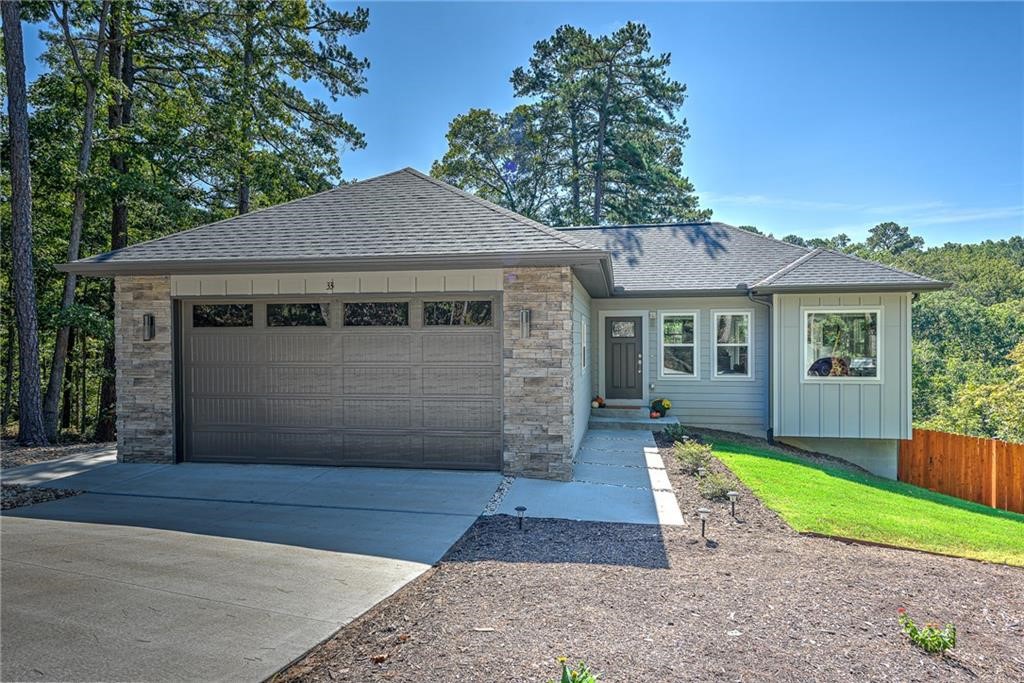 Open House this weekend - Saturday 1-3pm, Sunday 2-4pm. Welcome to 33 Shropshire Drive, a unique modern home built in 2020 and tucked away at the end of a quiet cul-de-sac on the east side of Bella Vista. Enjoy a private setting with wooded views out the back, while still being just 2 minutes from Highway 71 and only 20 minutes to Bentonville. This home features 4 bedrooms, 2.5 bathrooms, and two separate living areas, offering flexibility for family, guests, or a home office. The kitchen includes granite counters, modern cabinetry, and direct access to a deck overlooking the trees. Extras include: spacious garage with room for storage or workbench, upgraded 8ft tall garage door, outdoor shower / bike wash for easy cleanup after your rides, and a fully fenced backyard for pets or play. This listing (MLS 1323150) includes two lots for a total of 0.64 acres; it is also listed separately as the house on 0.32 acres without the extra lot (MLS 1323363).