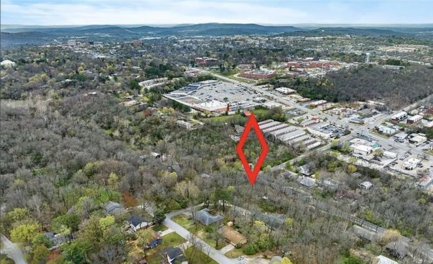Situated at the corner of E. Sycamore and Walnut, this approximately one-third acre wooded lot offers both convenience and privacy. Just minutes from the NWA Mall and close to all the amenities you need, it's an ideal location that blends accessibility with a secluded feel. All utilities are available at the street, making it ready for your custom home build. Enjoy the spaciousness of this lot while still having room to create your private retreat in the city. Walking distance to new school with completion date of 2028. Don't miss your chance to own this prime piece of property—come see it before it's gone!