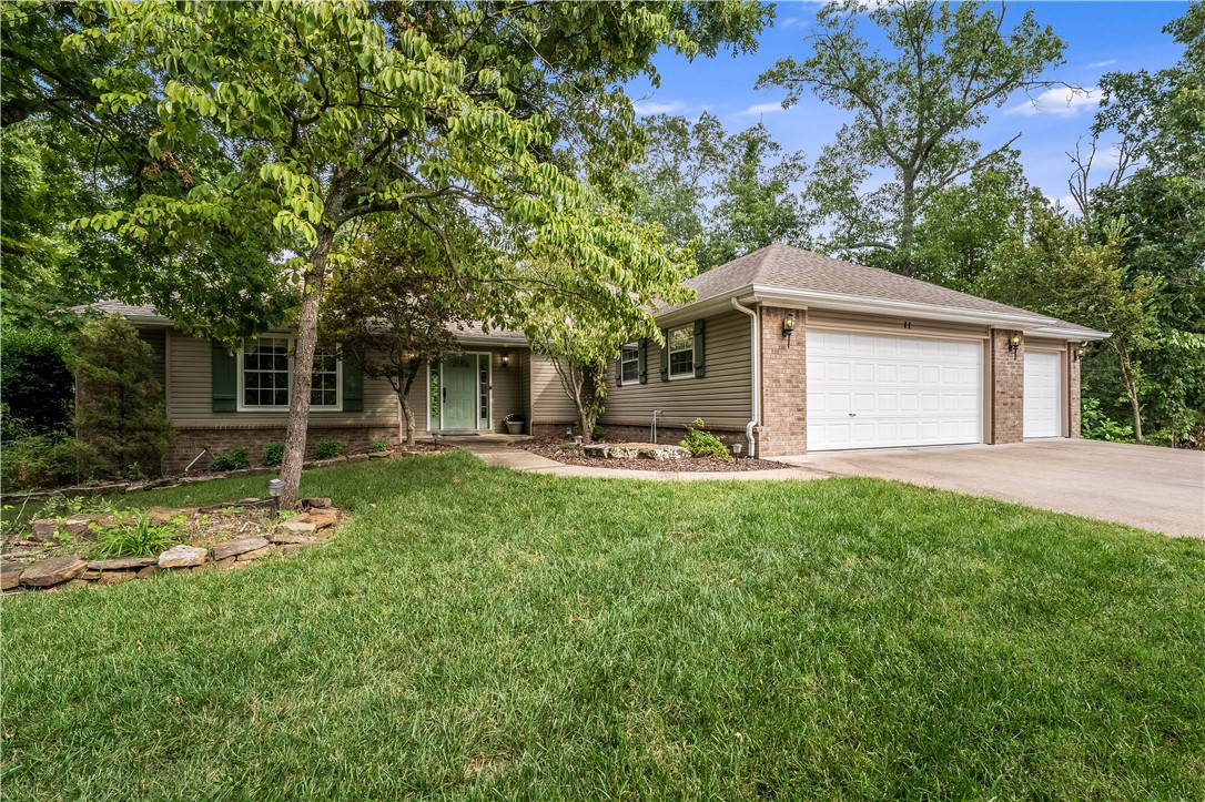 Just around the corner from the Blowing Springs Back 40 Trailhead for biking, minutes to Blowing Springs Park and the Gear Garden, restaurants, shopping and healthcare for you and your puppy! Lovely curb appeal with a tree filled yard and extensive landscaping, this hard to find three car garage home exudes curb appeal. This home features a lovely living area with gas log fireplace, open to a spacious dining room with hardwood flooring. The kitchen with bar seating, has great cabinet space, pantry and built in desk. This is a split bedroom plan with a spacious primary bedroom and attached bath. There is a secondary bedroom and bath plus an office/ possible 3rd bedroom with hardwood flooring and closet. Outdoor space great for entertaining... Bring your grill and enjoy the multi level covered deck and tree lined back yard! Additional lot to the right also available! Wood flooring 2019, HVAC 2013, roof 2012, gutter guards 2022, irrigation system front yard 2023.